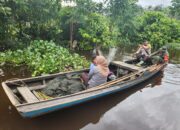 Salut, Bhabinkamtibmas Kempas Bersama Babinsa Kompak, Antar Warga Pulang Lewati Sungai Gunakan Perahu Motor