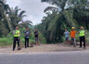 Gotong Royong Bersama Warga, Anggota Lantas Kandis Bersihkan Jalan Lintas